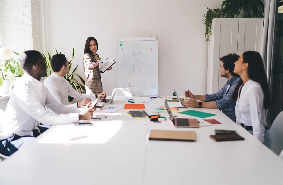 Mujer presentando una estrategia de negocio a un equipo diverso
